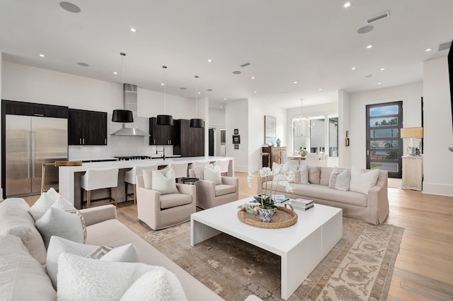 living room with a notable chandelier and light wood-type flooring