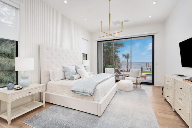 bedroom featuring an inviting chandelier, access to outside, and light hardwood / wood-style flooring