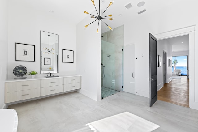 bathroom with hardwood / wood-style floors, vanity, an enclosed shower, and a notable chandelier