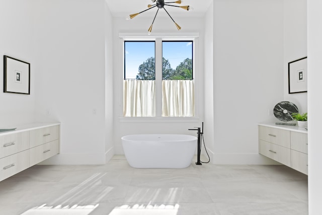 bathroom featuring a bathtub, vanity, and an inviting chandelier