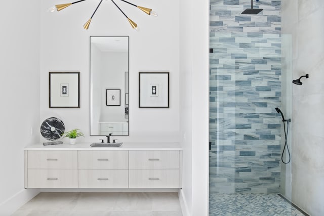 bathroom with a tile shower and vanity