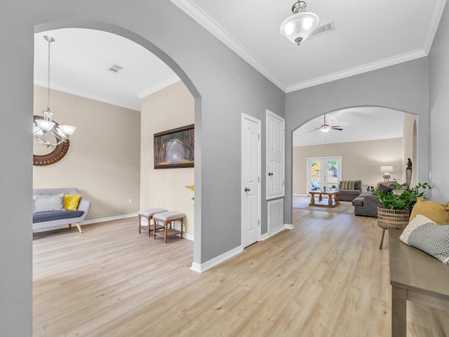 corridor featuring crown molding, light hardwood / wood-style flooring, french doors, and an inviting chandelier