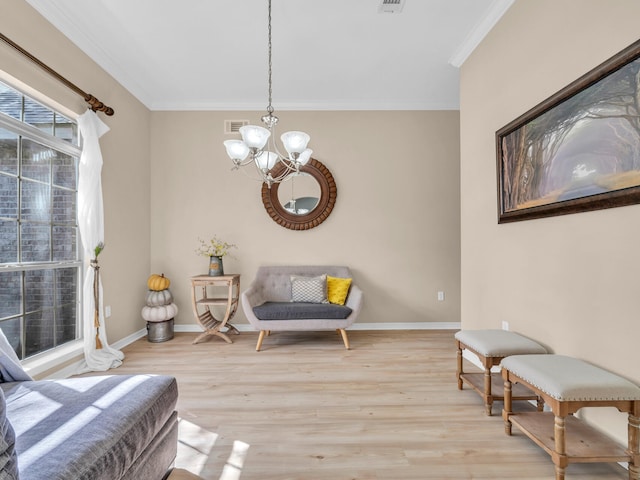 sitting room featuring crown molding, a chandelier, and light wood-type flooring