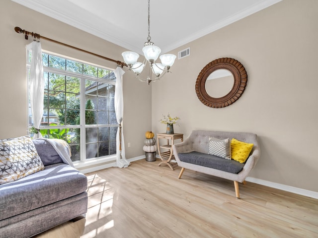 sitting room featuring ornamental molding, light wood-type flooring, and a notable chandelier