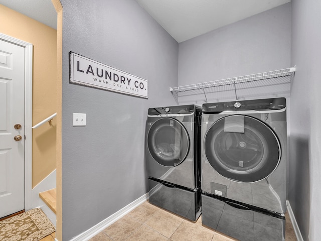 laundry area with light tile patterned floors and washing machine and dryer