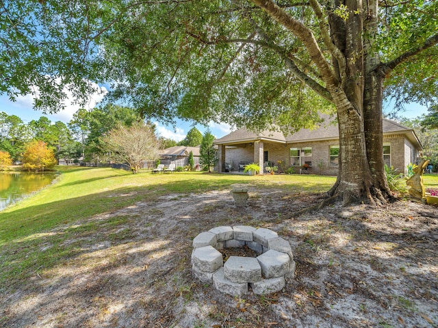 view of yard featuring a water view and a fire pit