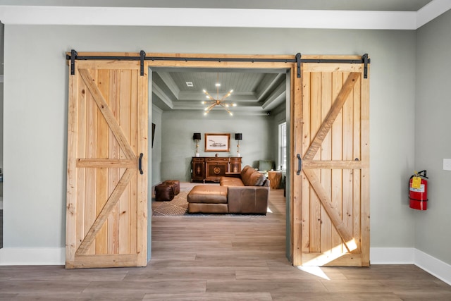 living room with a barn door, hardwood / wood-style flooring, and a notable chandelier