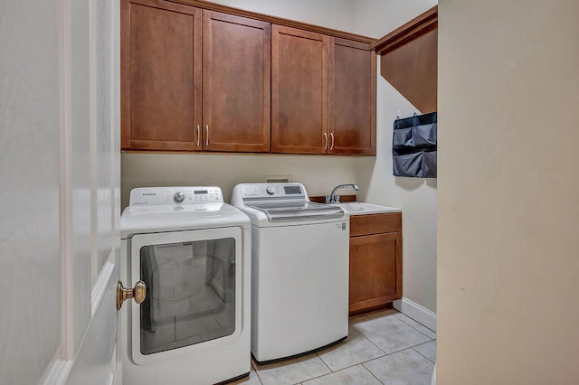 laundry area with cabinets, sink, separate washer and dryer, and light tile patterned floors