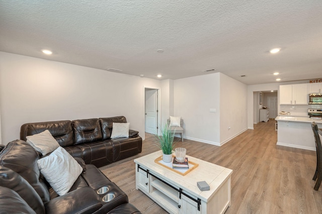 living room featuring a textured ceiling and light hardwood / wood-style flooring