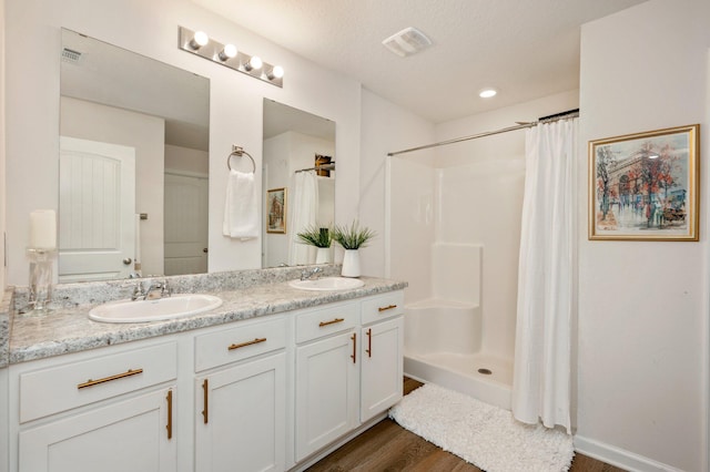 bathroom featuring hardwood / wood-style floors, a shower with shower curtain, a textured ceiling, and vanity