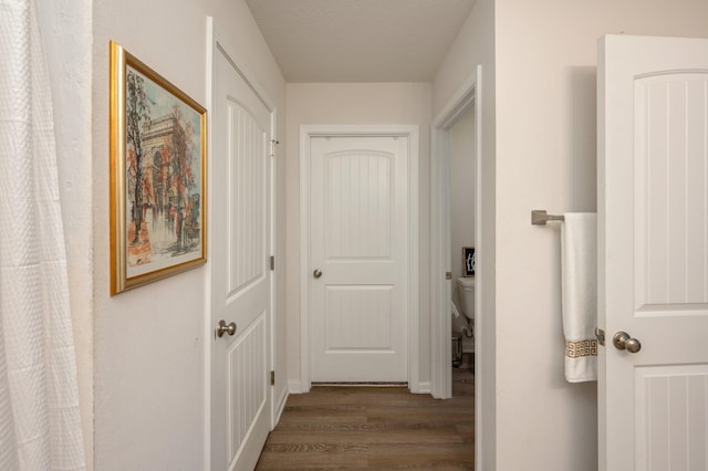 corridor featuring dark hardwood / wood-style floors and a textured ceiling