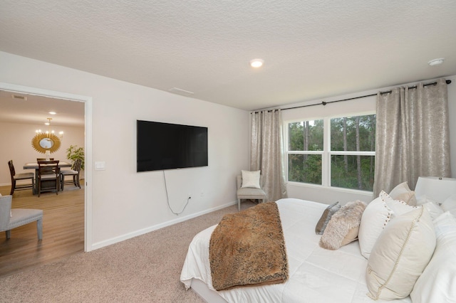 carpeted bedroom featuring a textured ceiling and a notable chandelier