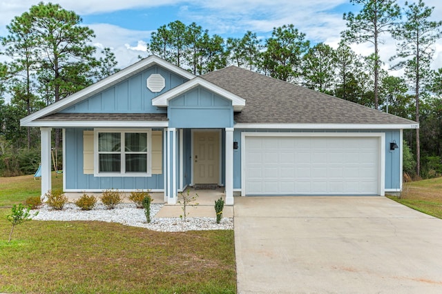 view of front of property with a garage, a front lawn, and a porch