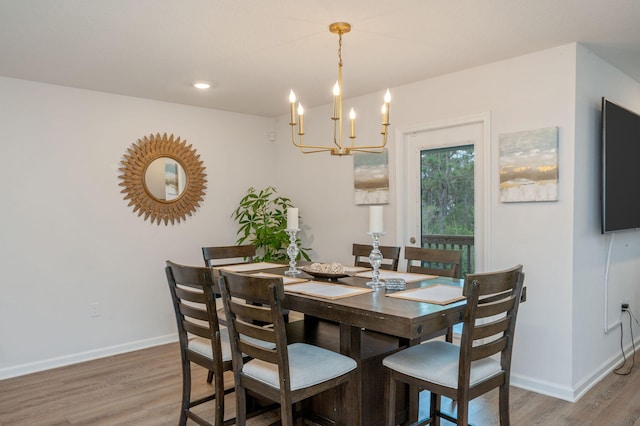 dining area with hardwood / wood-style flooring and a notable chandelier