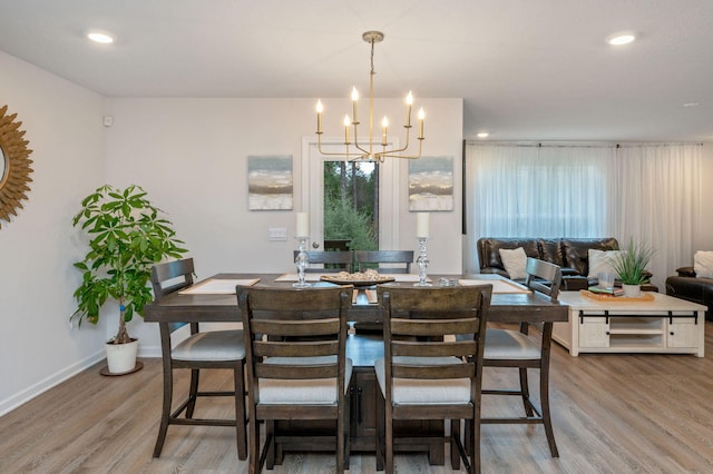 dining area with light hardwood / wood-style floors and a notable chandelier