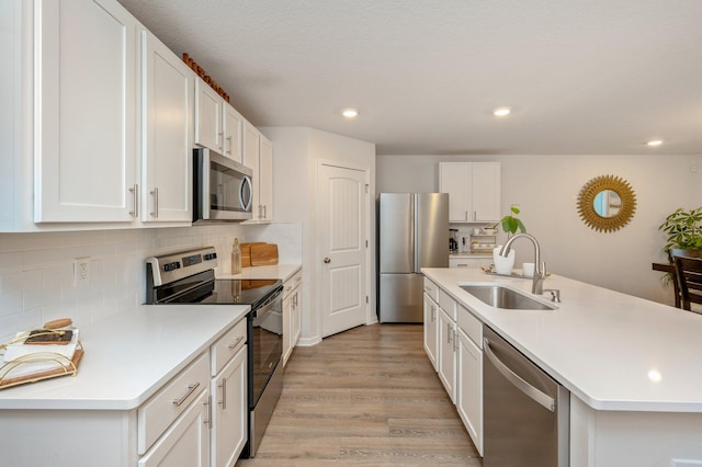 kitchen featuring white cabinets, light hardwood / wood-style floors, sink, and appliances with stainless steel finishes