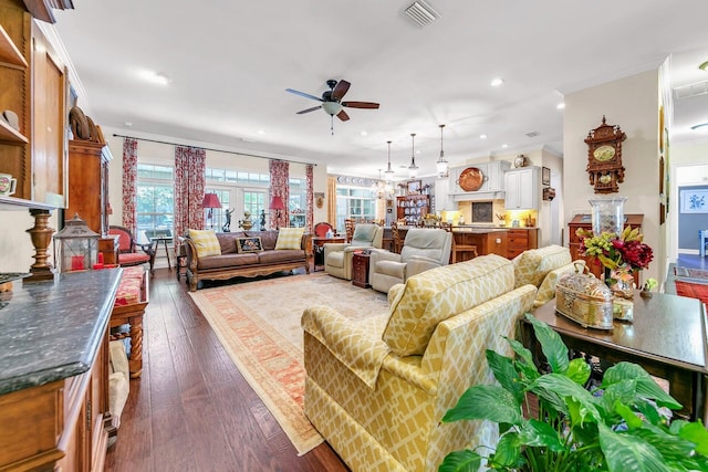 living room featuring dark wood-type flooring and ceiling fan with notable chandelier
