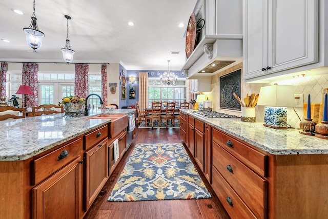 kitchen with a spacious island, dark hardwood / wood-style floors, and decorative light fixtures