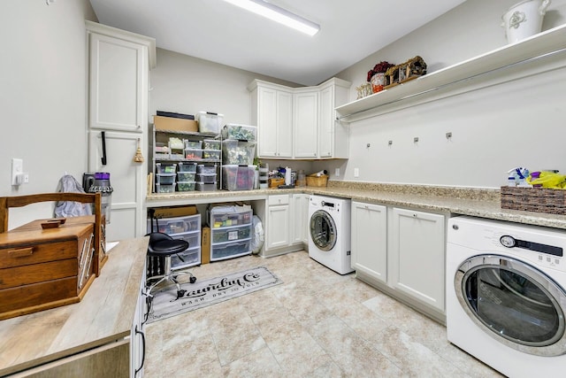 washroom with washer and dryer and cabinets