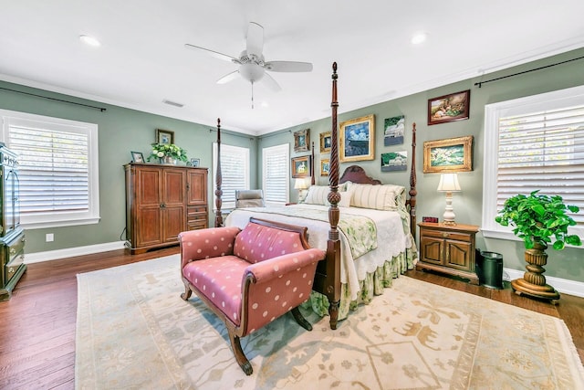 bedroom featuring multiple windows, dark hardwood / wood-style floors, and ceiling fan
