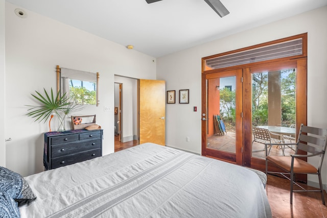 bedroom featuring access to outside, multiple windows, dark hardwood / wood-style floors, and ceiling fan