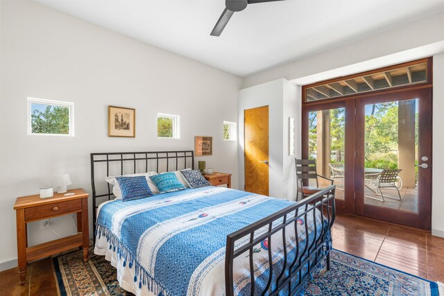 bedroom featuring dark tile patterned floors, access to outside, and ceiling fan