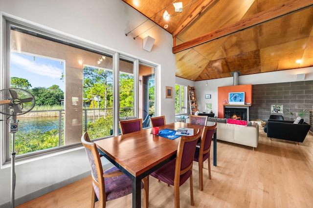 dining room featuring lofted ceiling with beams, wooden ceiling, and light wood-type flooring