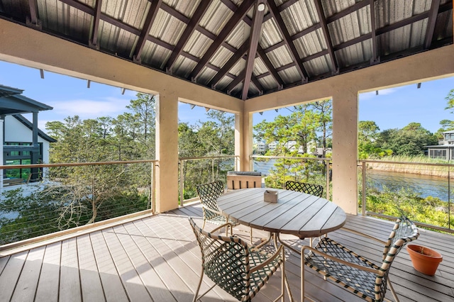 sunroom / solarium with lofted ceiling, a healthy amount of sunlight, and a water view