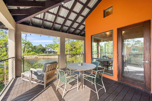 sunroom with vaulted ceiling with beams, a water view, and plenty of natural light