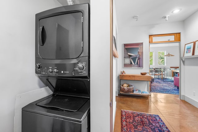 washroom featuring stacked washer / dryer and tile patterned flooring