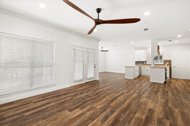 unfurnished living room with dark hardwood / wood-style flooring, ornamental molding, and ceiling fan