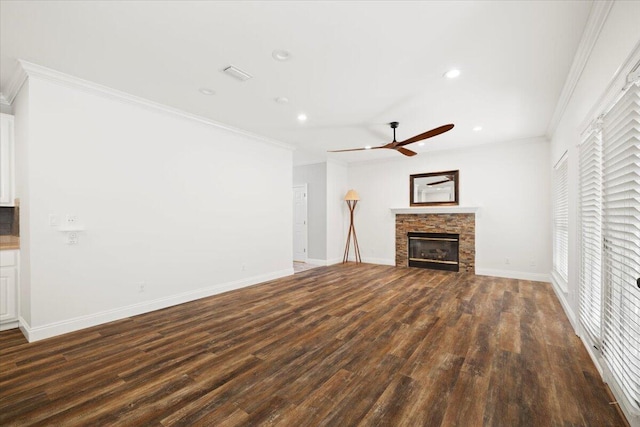 unfurnished living room with a stone fireplace, ornamental molding, ceiling fan, and dark hardwood / wood-style flooring