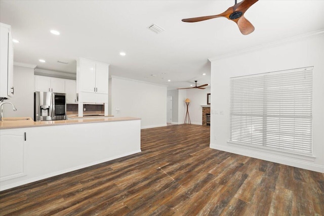 kitchen featuring white cabinets, ornamental molding, dark hardwood / wood-style floors, and stainless steel refrigerator with ice dispenser