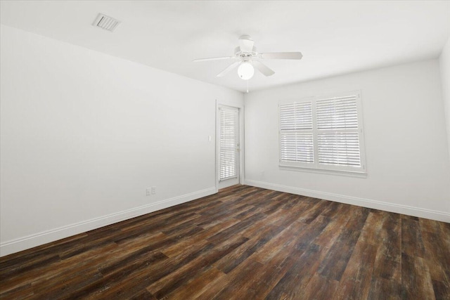 empty room with ceiling fan and dark hardwood / wood-style flooring