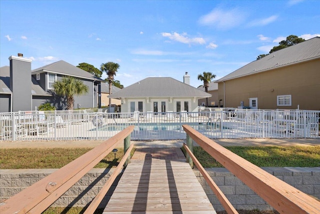 view of dock featuring a community pool and a patio area