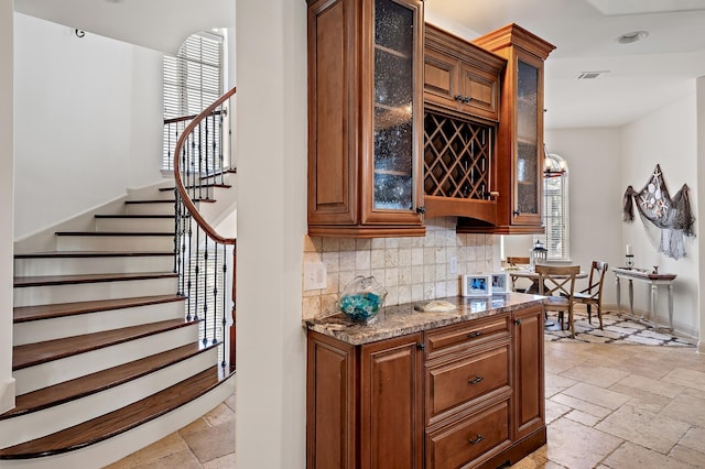 bar featuring decorative backsplash and dark stone counters