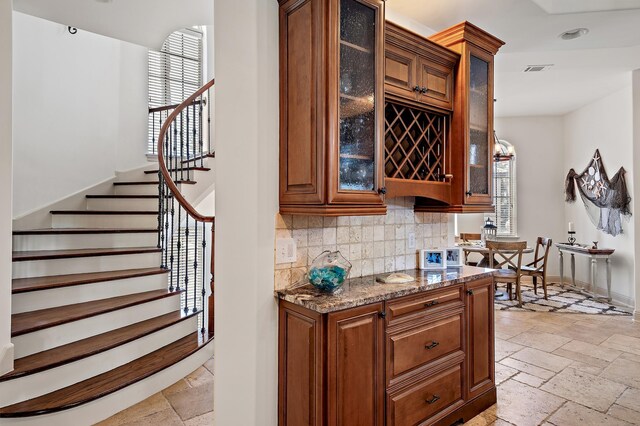 215 Rue St, Tropez, Miramar Beach, FL 32550 - bar featuring stairs, baseboards, stone tile flooring, and tasteful backsplash
