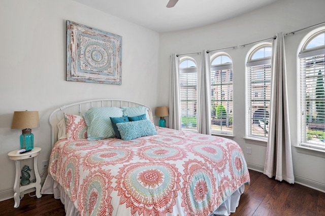 bedroom with multiple windows, dark hardwood / wood-style floors, and ceiling fan