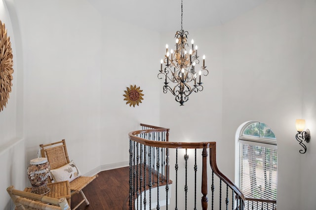 stairway featuring hardwood / wood-style flooring, a chandelier, and a high ceiling