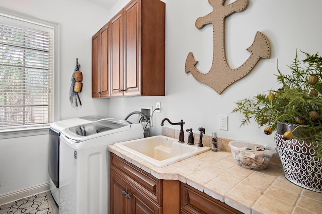 laundry room featuring cabinets, sink, and washing machine and clothes dryer