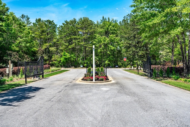 23 S J Hunters Way Lot 63, Freeport, FL 32439 - view of asphalt road with traffic signs and a gated entry