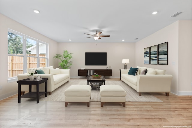 living room featuring ceiling fan and light hardwood / wood-style flooring