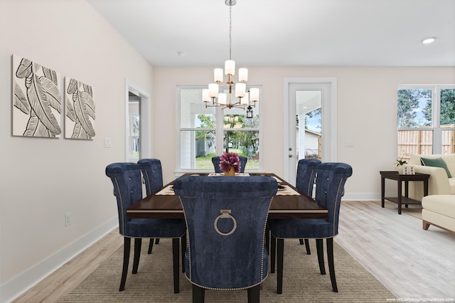 dining area featuring an inviting chandelier, hardwood / wood-style floors, and a healthy amount of sunlight