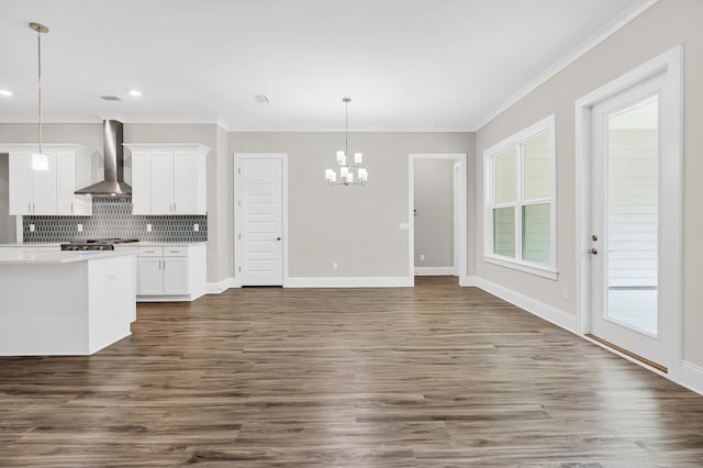 kitchen featuring wall chimney exhaust hood, dark hardwood / wood-style floors, hanging light fixtures, backsplash, and white cabinets