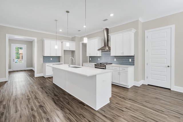 kitchen featuring white cabinetry, wall chimney range hood, gas stove, and sink