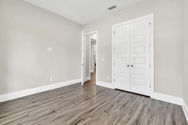 unfurnished bedroom with hardwood / wood-style floors and a closet