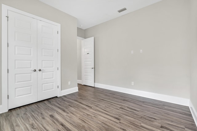 unfurnished bedroom featuring hardwood / wood-style floors and a closet