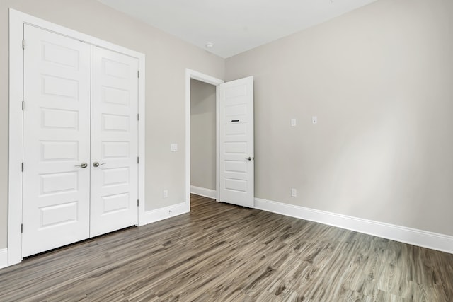 unfurnished bedroom with a closet and wood-type flooring