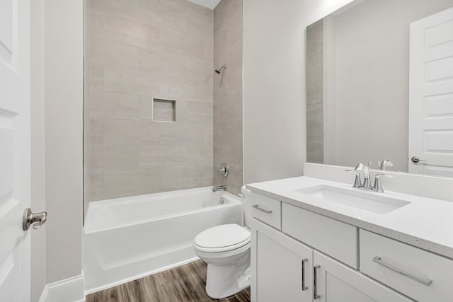 full bathroom with toilet, tiled shower / bath, wood-type flooring, and vanity