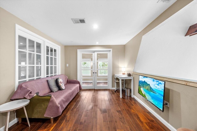 living room with dark hardwood / wood-style flooring and french doors